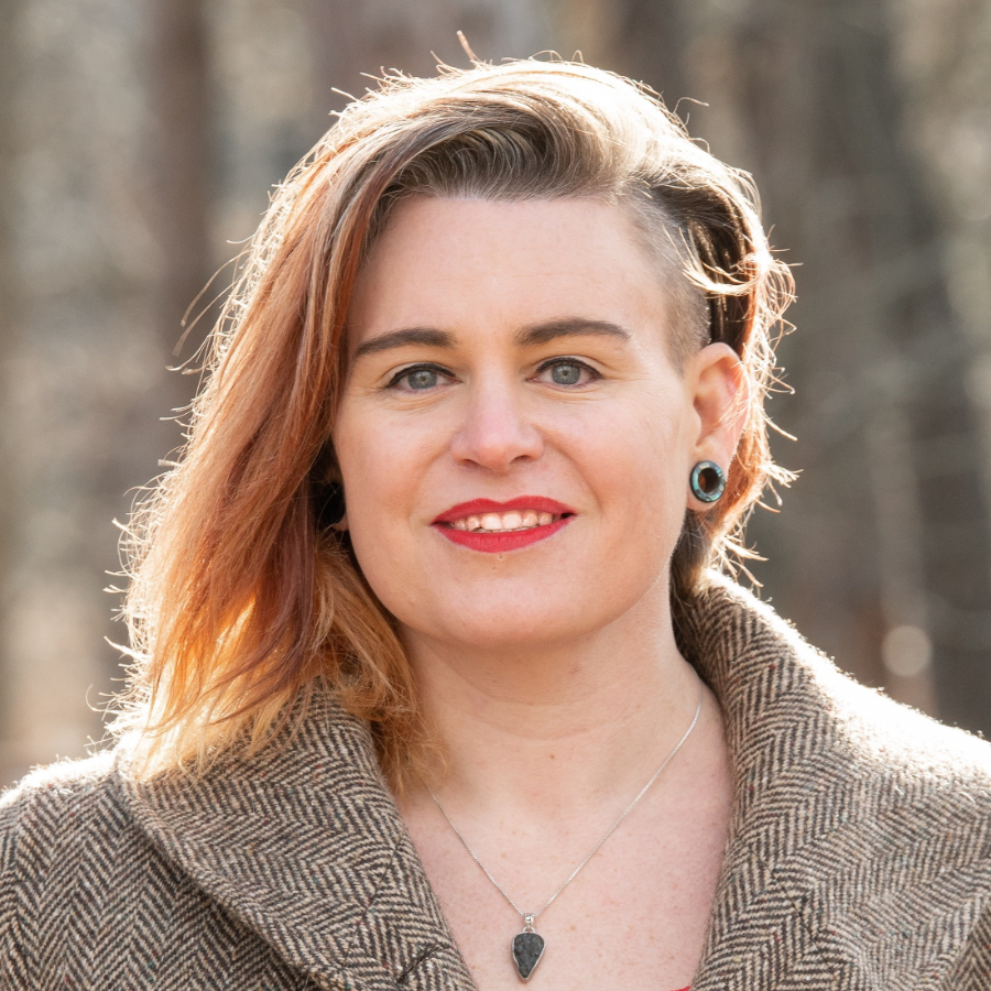 Photo of Kris Nóva with trees in blurred background, focused on her face.