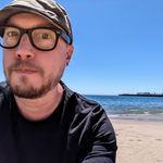 Photo of Dominic Hamon on a beach with the ocean visible in the background.